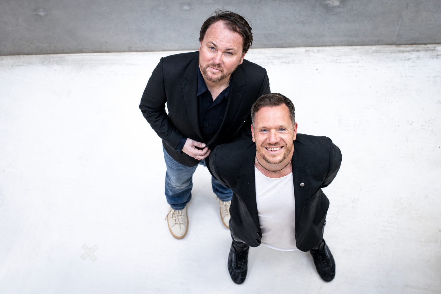 Olaf und Roland blicken gemeinsam zur Kamera auf.